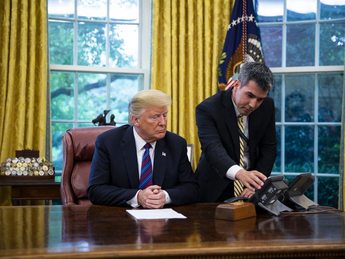 A White House aide assists Donald Trump connect a phone call with Enrique Pena Nieto on Aug. 27. Photographer: Al Drago/Bloomberg