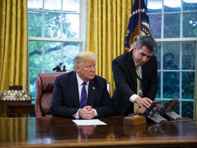 A White House aide assists Donald Trump connect a phone call with Enrique Pena Nieto on Aug. 27. Photographer: Al Drago/Bloomberg